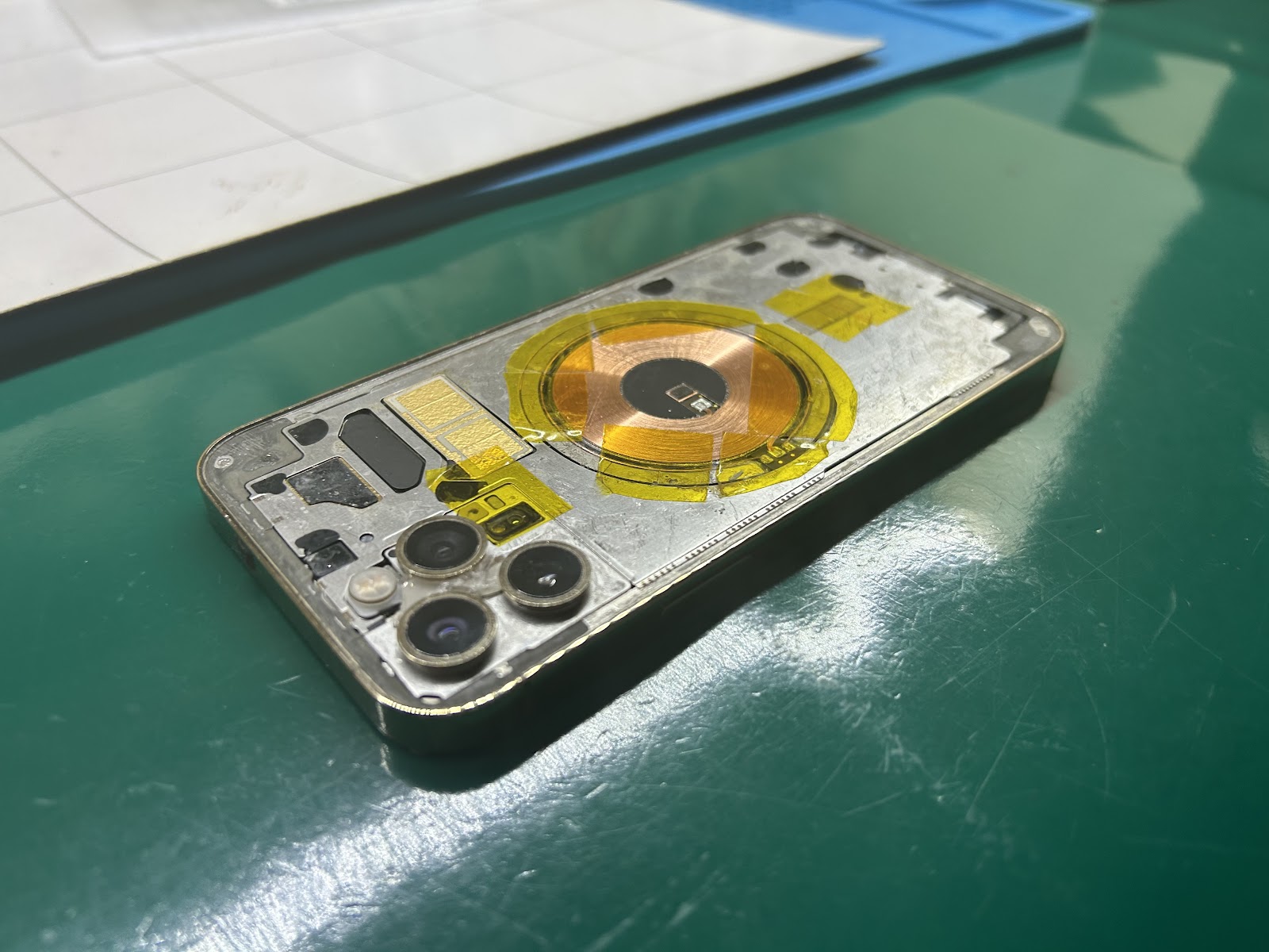 Rozłożony iPhone z widocznymi modułami aparatu na stole serwisowym