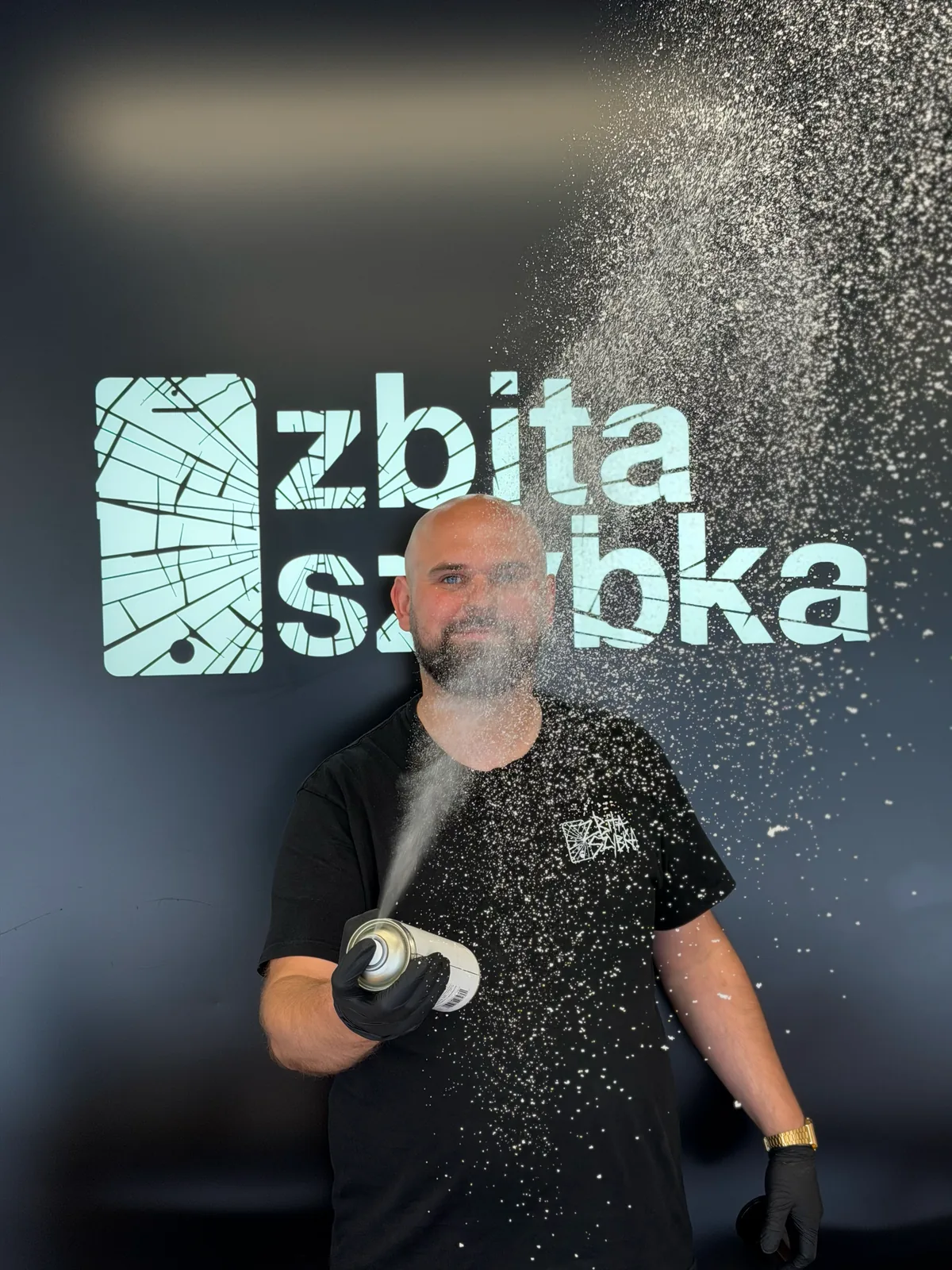 Serwisant czyszczący sprzęt na tle logo ZbitaSzybka